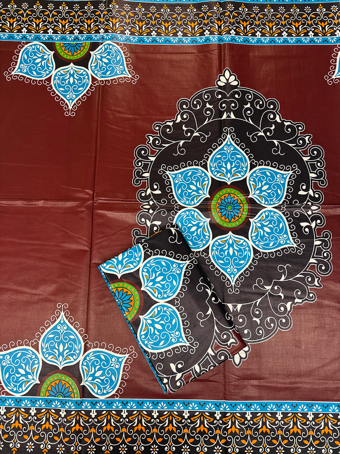 a dark reddish-brown base with a large black mandala-style floral motif outlined in white, bright blue petal shapes, and small green accents. Decorative borders repeat along the top and bottom edges.