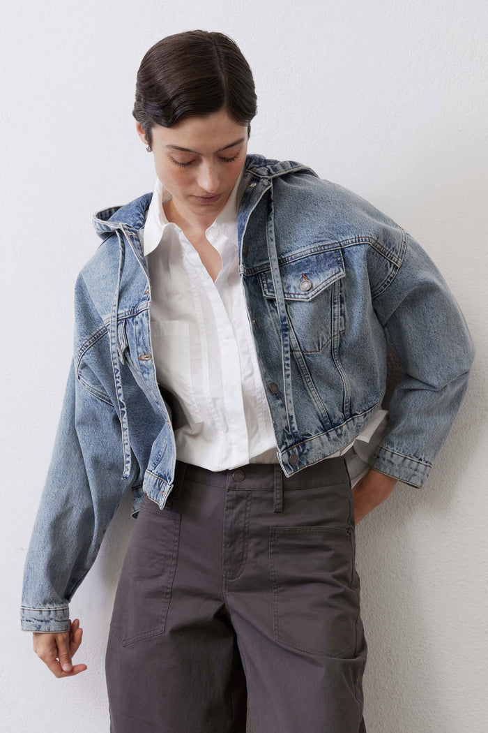 Washed blue denim jacket with button front, chest pockets, and long sleeves