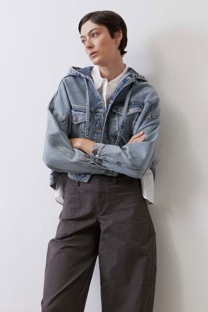 Washed blue denim jacket with button front, chest pockets, and textured denim stitching