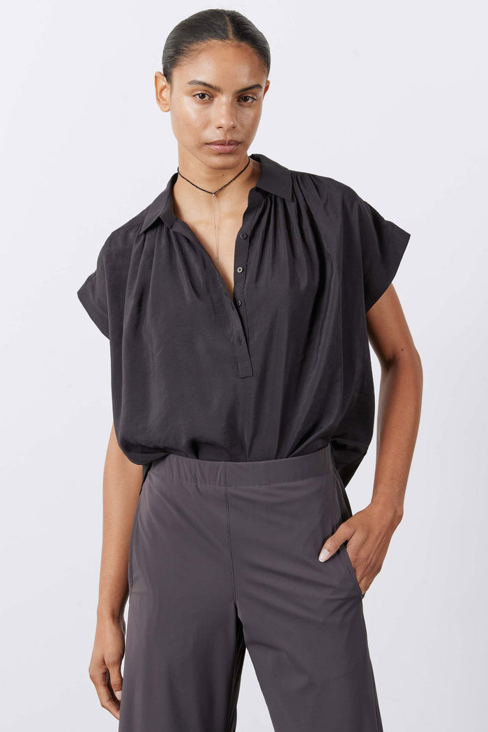 Black oversized voile blouse with collar, button placket, and short cape-like sleeves