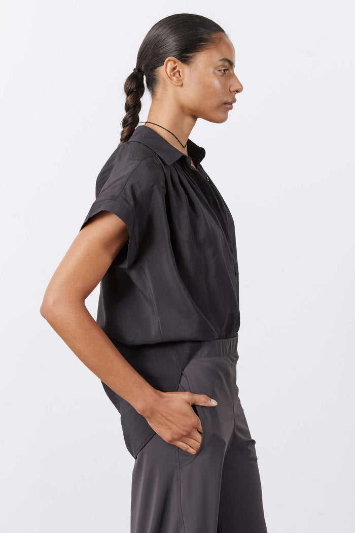 Black oversized voile blouse, short sleeves, V-neck placket, side profile view