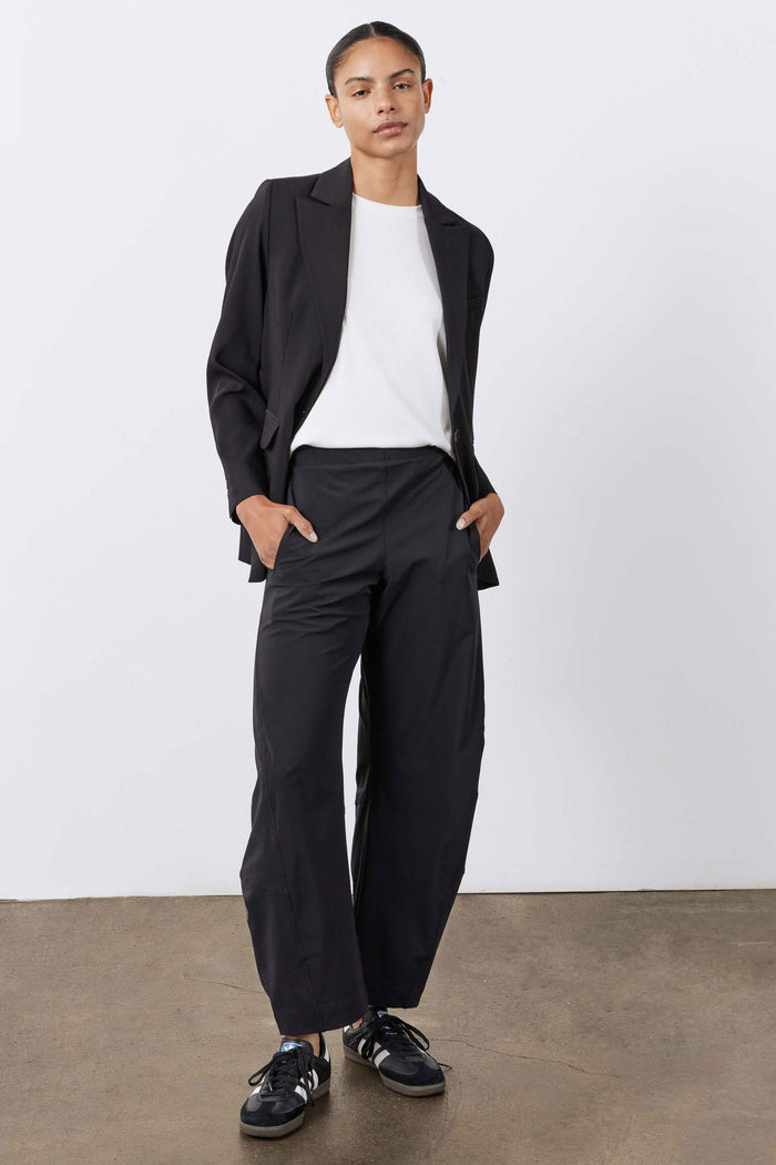 Black work pants with elastic waistband, deep pockets, and relaxed drape