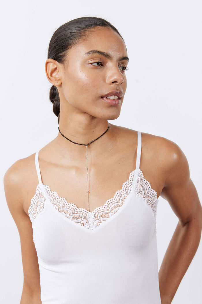 White lace-trim cami featuring scalloped lace V-neck and thin straps