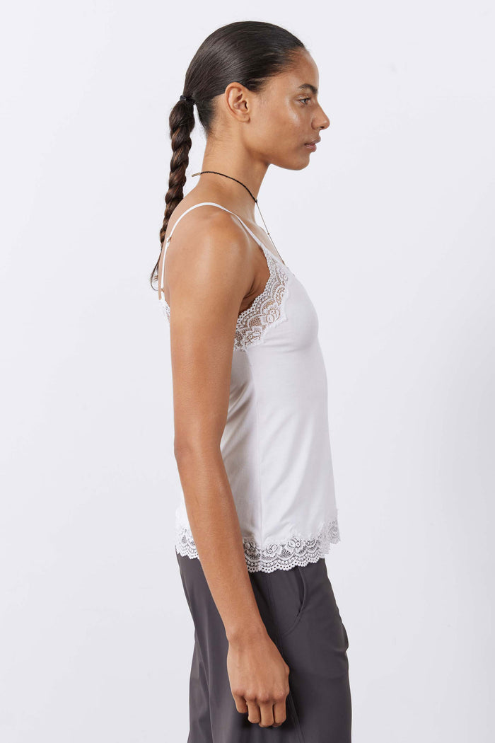 White lace-trim cami with spaghetti straps and scalloped hem, side view